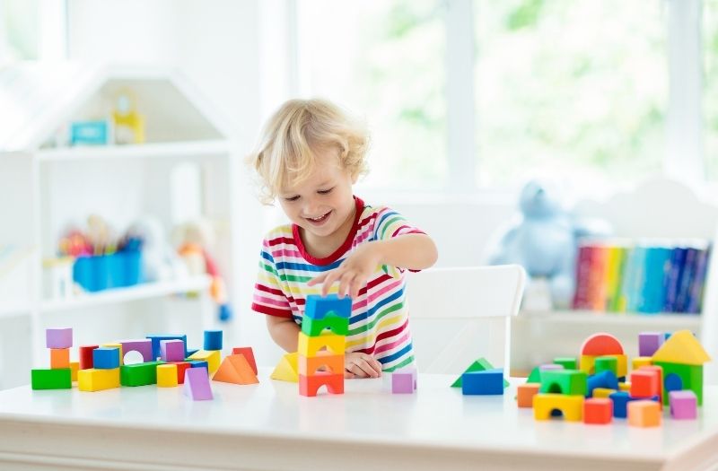 little boy playing with colorful blocks