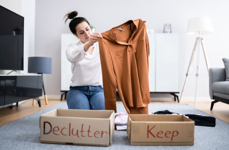 woman sorting her clothes to keep or declutter